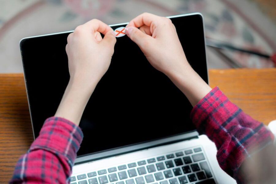 A person is using a homemade webcam cover on his laptop