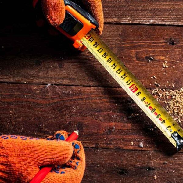 A person using a custom tape measure on a construction site