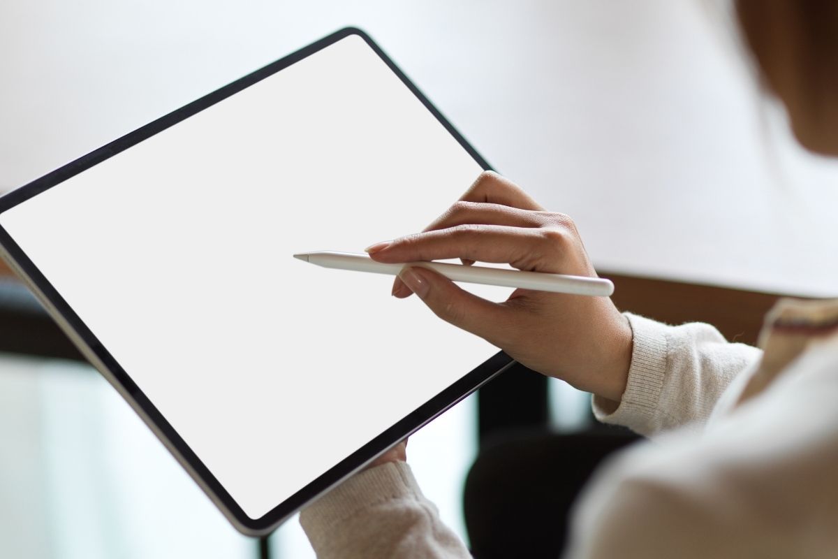 A woman is using a custom stylus pen on her tablet