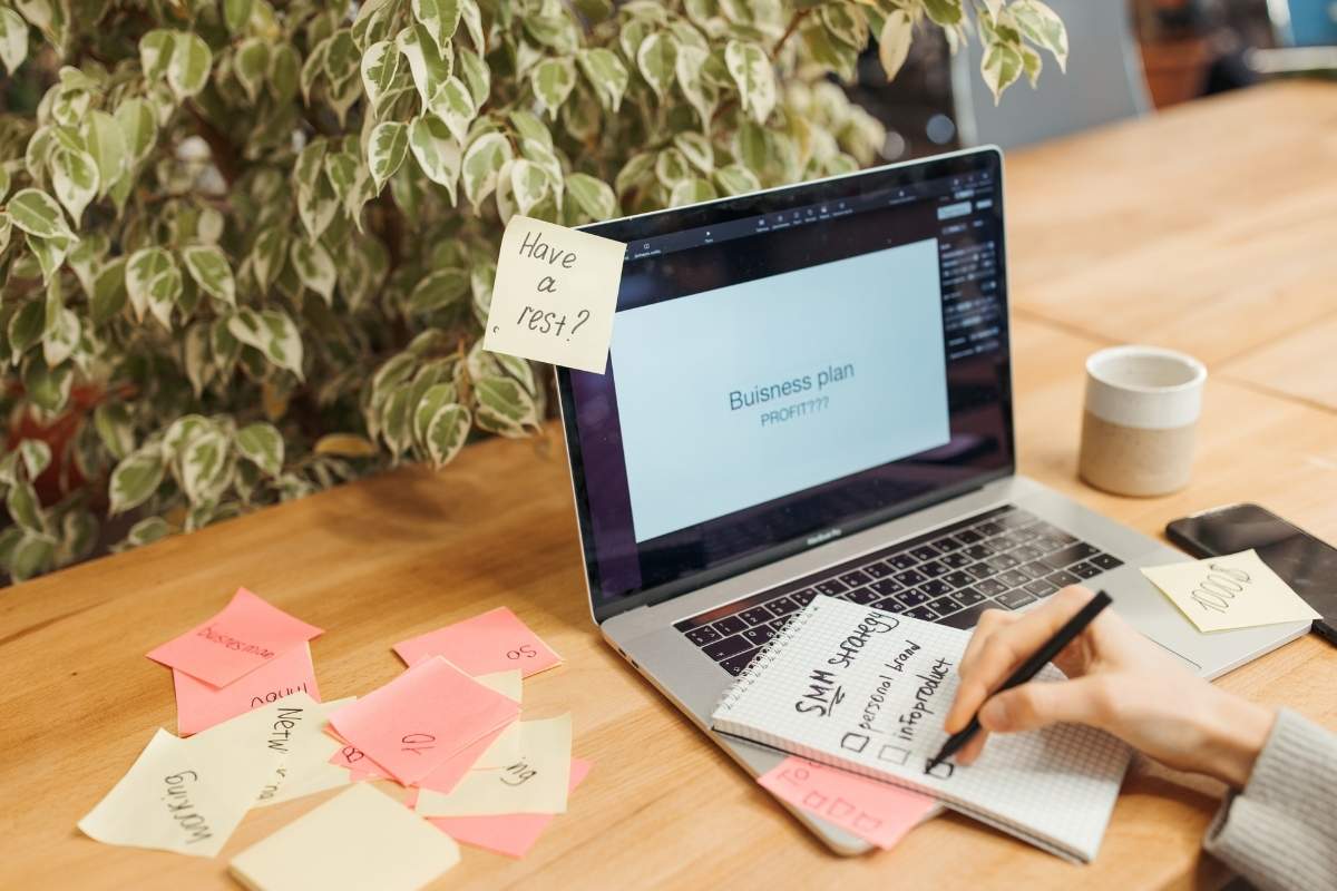 A woman using custom sticky notes as reminders while using her laptop