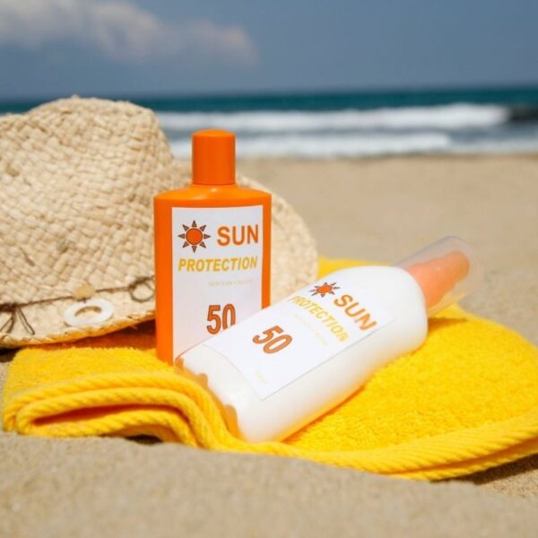 Two custom sunscreen bottles set side by side on the beach