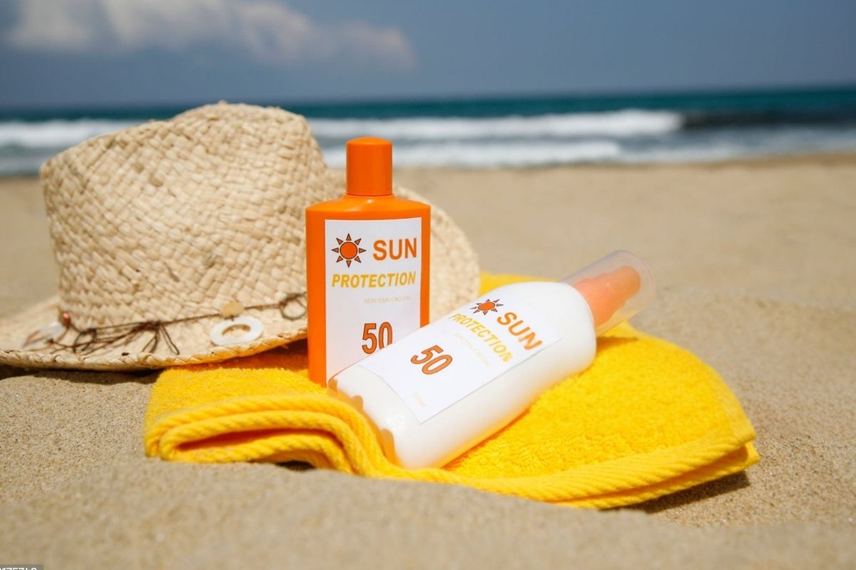 Two custom sunscreen bottles set side by side on the beach