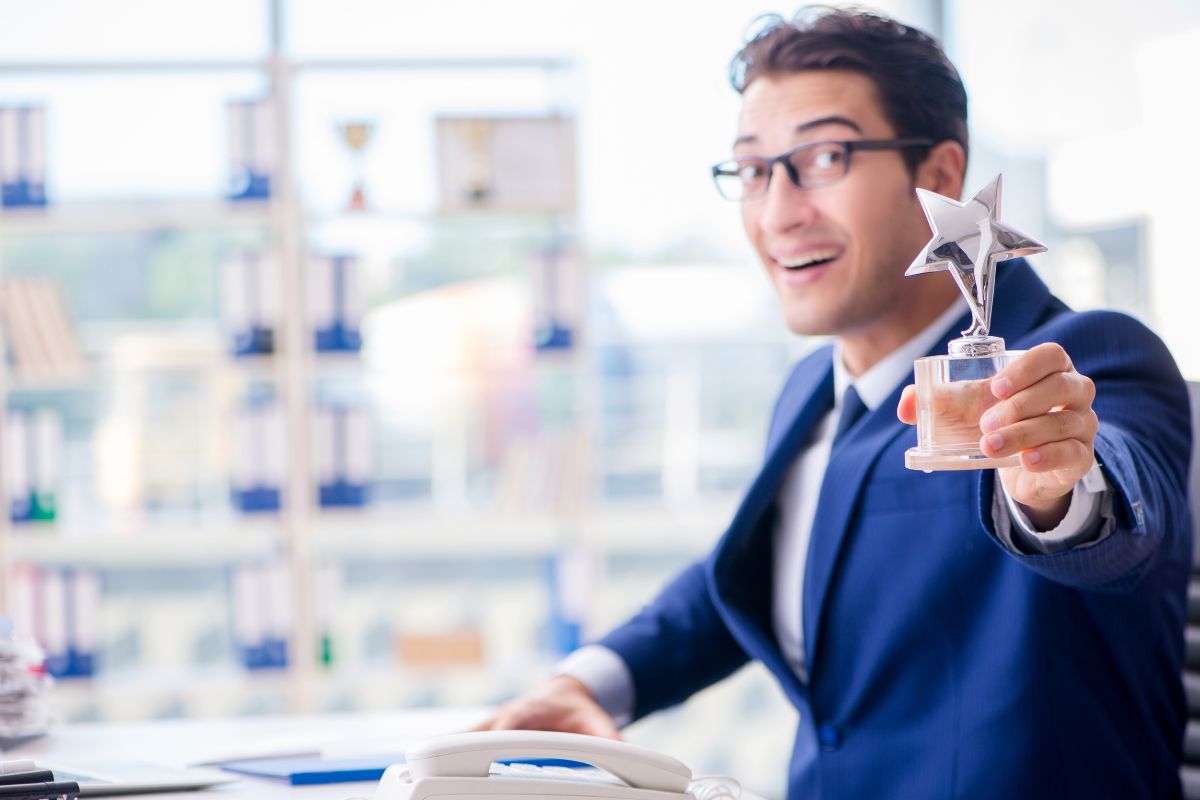 An employee showing his star performer of the year award